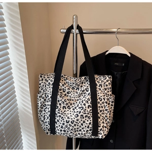 Detail of leopard print tote bag with wide nylon straps and functional front pockets