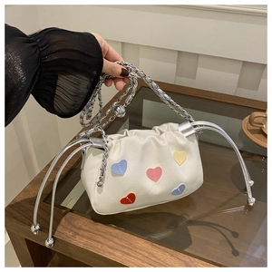 Détail du sac seau en toile avec cœurs colorés, chaîne argentée et cordon de serrage