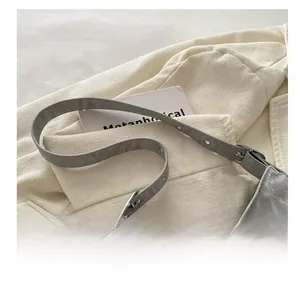 Détail du sac à bandoulière gris avec texture marbrée et ornement papillon argenté