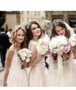 Three bridesmaids wearing sparkling rhinestone Maid of Honour headbands at a wedding