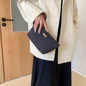 Quilted black nylon clutch bag with gold logo for women in minimalist autumn style