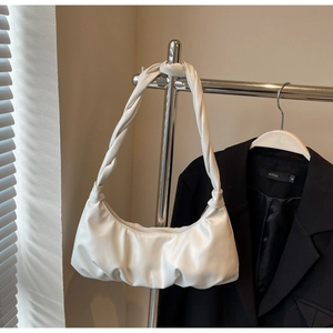 Détail d'un sac demi-lune blanc plissé avec une poignée tissée et torsadée élégante