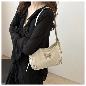 Sac bandoulière blanc cassé avec boucle papillon et détails de clous métalliques style Y2K