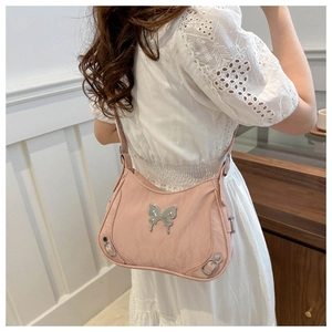 Détail du sac Hobo rose avec boucle papillon métallique et œillets en argent