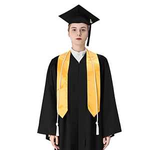 Close-up of black graduation gown set with yellow honor stole and cap with tassel
