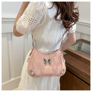 Détail du sac à bandoulière rose clair avec fermoir papillon et rivets argentés