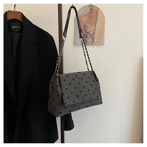 Detailed view of grey shoulder bag with butterfly embroidery and silver chain strap