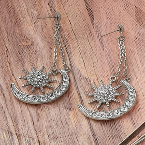 Detail of silver long tassel earrings with sparkling star and moon rhinestone accents