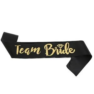 Detail of black satin Team Bride sash with metallic gold lettering for bachelorette parties