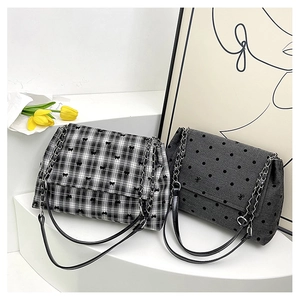 Detail of minimalist shoulder bags with butterfly embroidery and silver chain straps