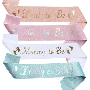 Close-up of glitter satin sashes for Mom and Dad to be in rose gold and teal colors