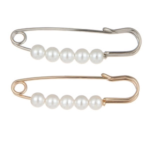 Detail of gold and silver safety pins with five white faux pearls for sashes