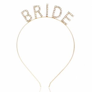 Close-up of golden metal headband featuring rhinestone-encrusted BRIDE lettering for parties