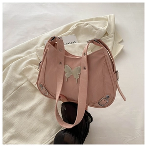 Gros plan du sac papillon rose montrant la boucle métallique et la texture du cuir plissé