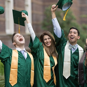Detail of dark green graduation gown and cap with golden tassel in university setting