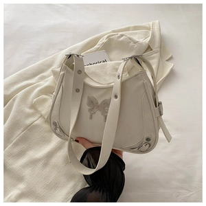Gros plan du sac hobo blanc avec ornement papillon argenté et détails de rivets en métal