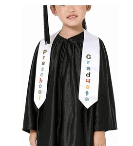 Detailed close-up of preschool graduate sash on black gown with colorful printed text
