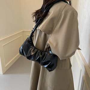 Sac à bandoulière noir plissé style nuage pour femme dans une tenue de ville élégante