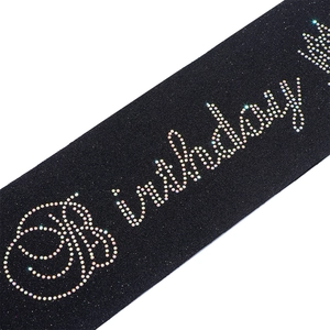 Détail de l'écharpe d'anniversaire noire avec strass colorés et motif de couronne