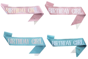 Close-up of glitter birthday girl sashes in pink and blue with metal safety pins