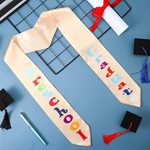 Macro shot of satin champagne preschool graduate sash with graduation decorative props
