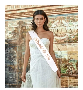 Detailed view of white satin Bride to Be sash with elegant gold foil lettering for weddings
