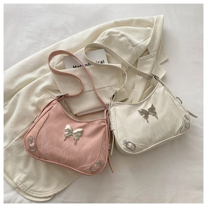 Détail de la texture plissée et du papillon en métal argenté sur les sacs hobo chics