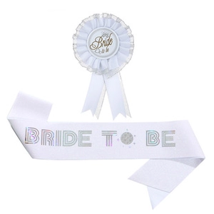 Detail of white satin Bride to Be sash and matching badge with holographic lettering
