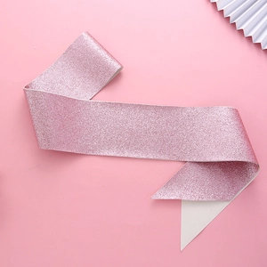 Close-up of pink glitter sash texture with white backing for birthday party sash decor