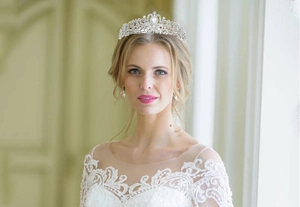 Close-up of a bride wearing a silver vintage crown with crystal rhinestones on white lace