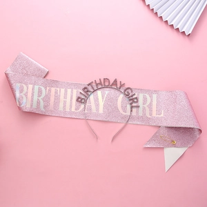 Close-up of pink glitter Birthday Girl sash with tiara headband and golden pin