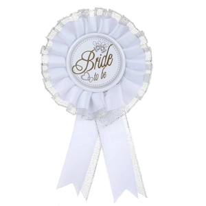 Close-up of a white satin Bride to be rosette badge with lace trim and gold lettering