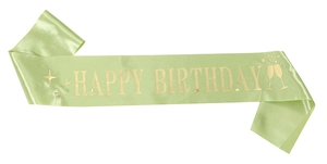 Detail of light green satin sash with gold foil Happy Birthday text and stars