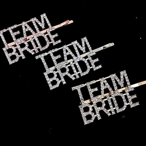 Macro shot of Team Bride rhinestone hairpins in rose gold, silver, and gold metal finishes