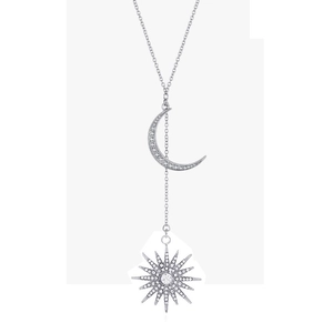 Silver Y-necklace featuring pavé crystal moon and sun starburst pendants on white background