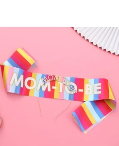Close-up of rainbow satin sash and rhinestone Mom To Be headband for baby shower parties