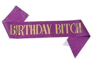 Detail of purple glitter sash featuring metallic gold Birthday Bitch foil lettering