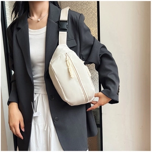 Détail d'un sac bandoulière blanc en nylon avec sangle réglable porté par un mannequin