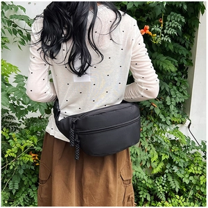 Détail du sac banane en nylon noir imperméable avec fermeture éclair et cordon tressé