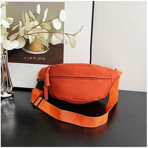 Détail d'un sac banane orange vif en nylon imperméable avec sangle et boucle de fermeture
