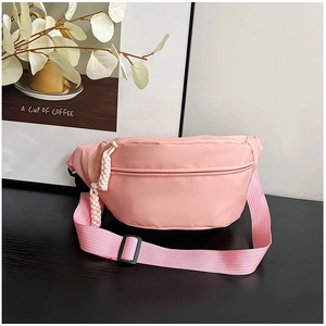 Détail du sac bandoulière en nylon rose avec tirette tissée et sangle réglable