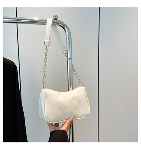 Close-up of white crescent shoulder bag with gold chain strap and faux leather texture