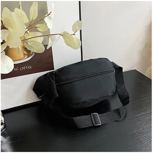 Détail du sac bandoulière en nylon noir imperméable avec sangle réglable et boucle sur bois