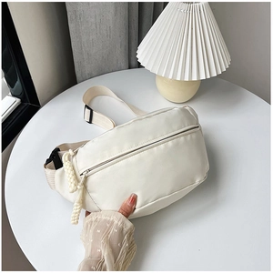 Détail du sac bandoulière en nylon crème avec zips en corde tressée et poche frontale