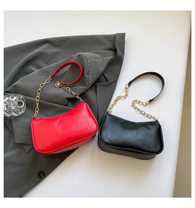 Detail showing red and black faux leather underarm bags with gold metal chain straps