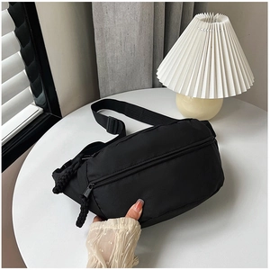 Détail d'un sac bandoulière noir en nylon imperméable avec sangle réglable et double fermeture