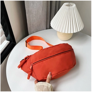 Détail du sac bandoulière imperméable en nylon orange avec tirette tissée élégante