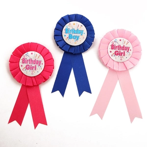 Detailansicht von drei Satin-Geburtstagsabzeichen in Blau und Pink für Jungen und Mädchen