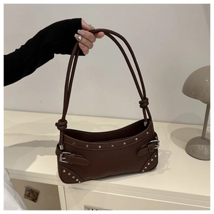Dettaglio borsa a spalla retrò in pelle marrone con borchie argentate e fibbie