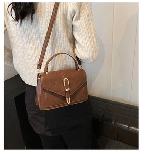 Détail d'un petit sac carré vintage marron avec patchwork et fermoir doré chic